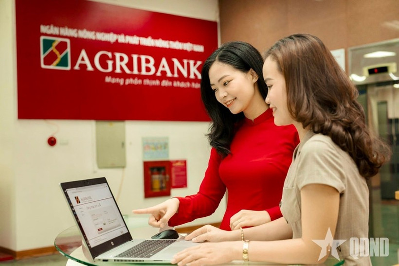 Des employés de la Banque vietnamienne de l’Agriculture et du Développement rural (Agribank) guident les clients dans la réalisation de transactions sécurisées sur les canaux numériques. Photo : Journal Quân đội nhân dân