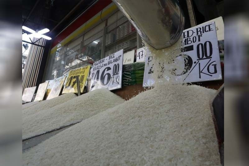 Des vendeurs de riz exposent leurs étals et leurs prix au marché Trabajo de Sampaloc, à Manille. (Photo : philstar.com)