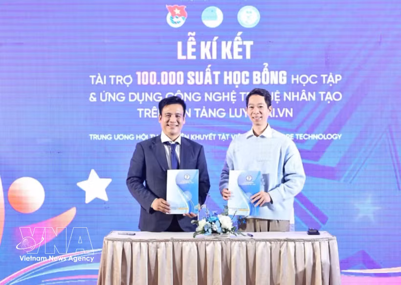 Pham Van Thành (à gauche), président de l'Association vietnamienne des jeunes handicapés, signe des accords de coopération avec JMB Vietnam et InfoRe Technology pour financer 100 000 bourses de formation à l'utilisation des outils d'IA sur la plateforme LuyenAI.vn. Photo : VNA