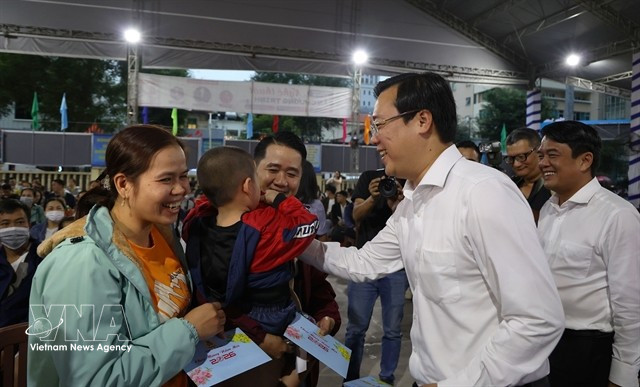 Lê Quôc Phong, secrétaire adjoint permanent du Comité du Parti de Hô Chi Minh-Ville, distribue des cadeaux aux travailleurs avant leur départ en bus pour rentrer chez eux le 12 février. Photo : VNA