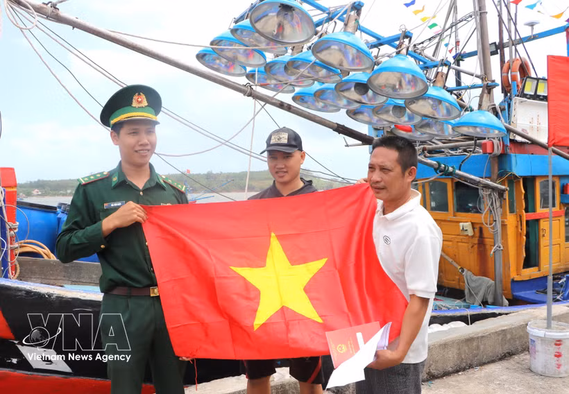 Remise de drapeaux nationaux à des pêcheurs. Photo : VNA