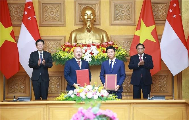 Le Premier ministre Pham Minh Chinh et le Premier ministre singapourien Lawrence Wong assistent à la remise d'un mémorandum de coopération entre des organisations des deux pays. Photo : VNA