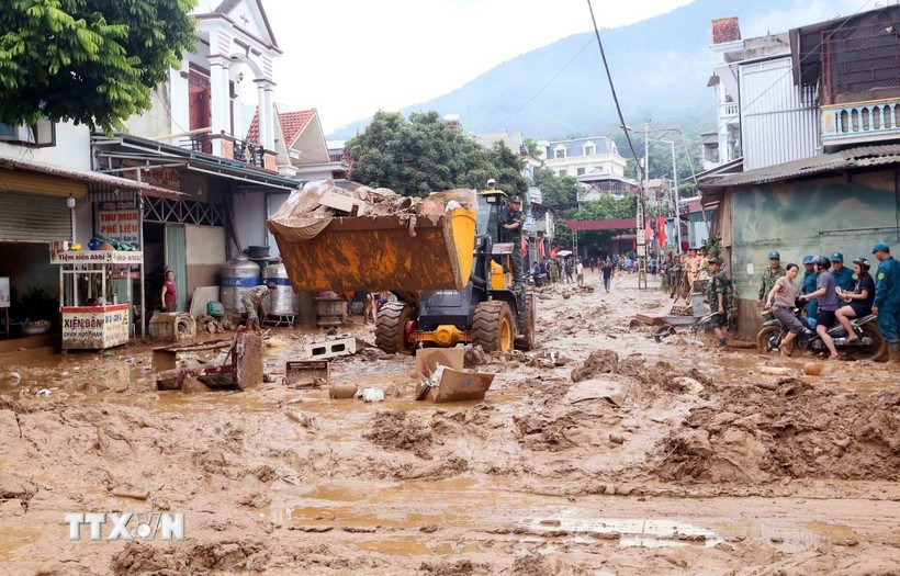Des excavatrices aident à ramasser la boue, les branches d'arbres et les déchets emportés par les récentes inondations dans la commune de Song Ma, province de Son La. Photo : VNA