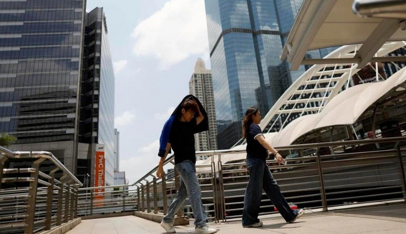 Un homme se protège du soleil sous une chaleur accablante à Bangkok, en Thaïlande. Photo : EPA