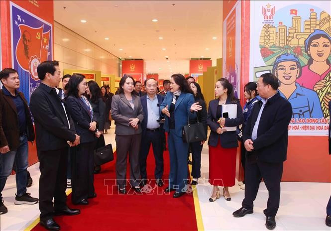 La vice-directrice générale de l’Agence vietnamienne d’Information (VNA), Nguyen Thi Su, présente à la vice-présidente Vo Thi Anh Xuan l'exposition photographique de la VNA dans le cadre du XIᵉ Congrès national d’émulation patriotique. Photo : VNA