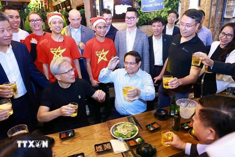 Le Premier ministre Pham Minh Chinh et Jensen Huang, fondateur et directeur général du groupe NVIDIA, dégustent la cuisine de rue à Hanoï dans la soirée du 5 décembre 2024. Photo: VNA