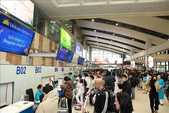 Des passagers de Vietnam Airlines effectuent des procédures d'embarquement à l'aéroport. Photo d'illustration: VNA