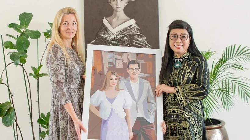 Lê Thi Bich Tran offre à Evelin Oras une œuvre d'art originale et symbolique : un portrait du couple estonien réalisé à partir de près de 2.000 morceaux de tissu. Photo: VNA