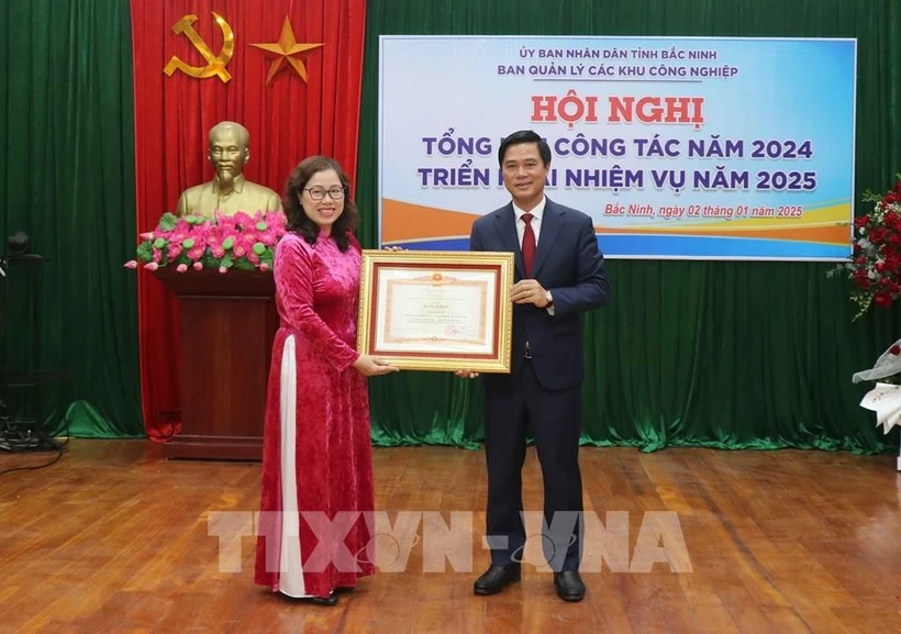 Le vice-président du Comité populaire provincial de Bac Ninh, Le Xuan Loi, remet le satisfecit du Premier ministre à Le Thi Thu Huyen, directrice adjointe du Comité de gestion des parcs incustriels de Bac Ninh. Photo: VNA