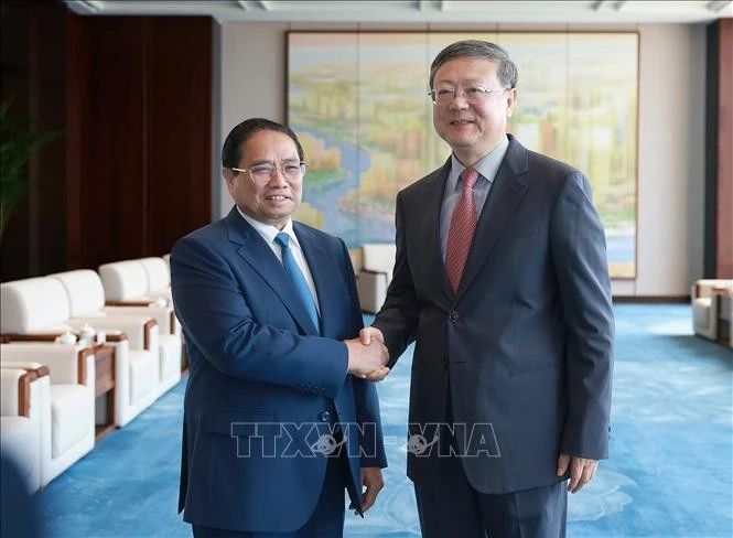 Le Premier ministre Pham Minh Chinh (gauche) et Chen Jining, membre du Bureau politique du Comité central du Parti communiste chinois (PCC) et secrétaire du Comité du PCC pour la ville de Shanghai. Photo: VNA