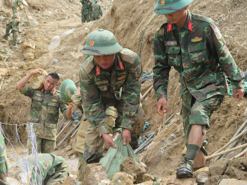 Des soldats s'efforcent de dégager les routes menant aux villages isolés par les inondations. Photo: VNA
