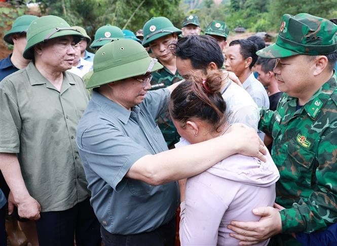 Le Premier ministre Pham Minh Chinh et des sinistrés. Photo: VNA