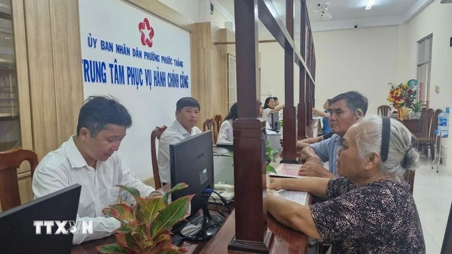 Des personnes viennent effectuer des démarches administratives lors du premier jour de mise en place du modèle d'administration locale à deux niveaux dans le quartier de Phuoc Thang, à Hô Chi Minh-Ville. Photo : VNA