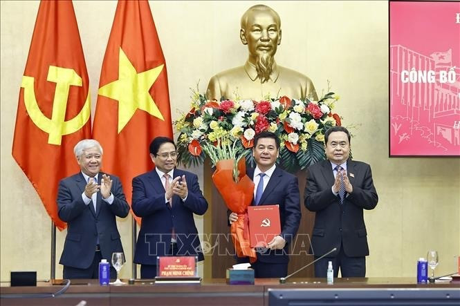 Le président de l’Assemblée nationale, Tran Thanh Man, a remis la décision, et le Premier ministre Pham Minh Chinh a offert des fleurs pour féliciter Nguyen Hong Dien. Photo: VNA