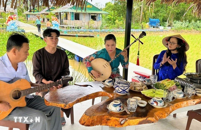Spectacle de musique folklorique traditionnelle sur le site d'écotourisme et de tourisme rural de Canh Dong Cau Ba. Photo : VNA