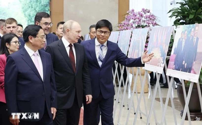 Le Premier ministre Pham Minh Chinh et le président russe, Vladimir Poutine, visitent une exposition de photos sur la coopération entre les deux pays. Photo: VNA