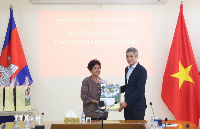 L'ambassadeur Nguyen Minh Vu remet des cadeaux du Têt à Ha Thi E, qui a contribué à la résistance contre l'armée américaine et a reçu un certificat de mérite du Premier ministre vietnamien en 2009. Photo : VNA