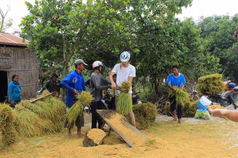 Un touriste étranger découvre le travail agricole à An Giang. Photo : VNA