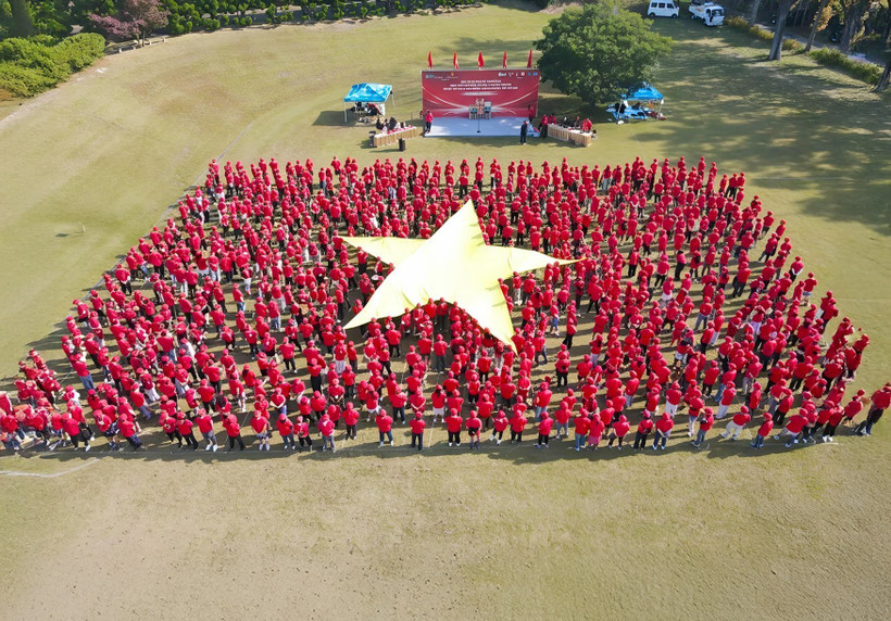 Plus d'un millier de Vietnamiens forment ensemble le Drapeau rouge à l’étoile d’or. Photo: VNA