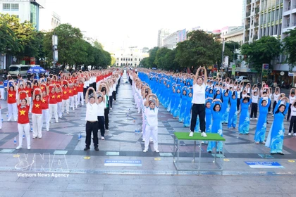 Professionnels de la santé et résidents de Hô Chi Minh-Ville pratiquent ensemble des exercices de promotion de la santé. Photo: VNA