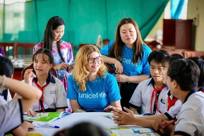 Des membres du personnel de l’UNICEF participent à une discussion avec des enfants vietnamiens. Le partenariat de 50 ans entre le gouvernement vietnamien et l’UNICEF a connu une transformation significative. Photo : UNICEF Vietnam
