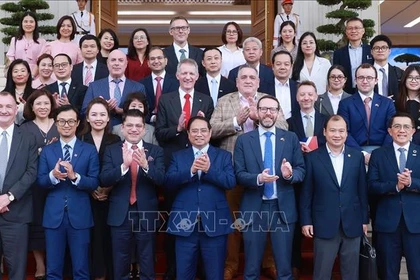 Le Premier ministre Pham Minh Chinh pose pour une photo souvenir avec les délégués lors de l'événement, à Hanoi, le 28 juin. Photo: VNA