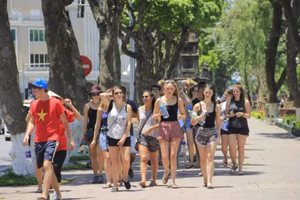 Des touristes étrangers sous un soleil ardent à Hanoi. Photo : VTC News