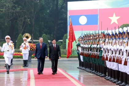 Le secrétaire général du Parti révolutionnaire populaire lao et président lao, Thongloun Sisoulith, accompagné du secrétaire général du Parti communiste du Vietnam, Tô Lâm, passe en revue la garde d’honneur, à Hanoi, le 26 janvier 2026. Photo : VNA