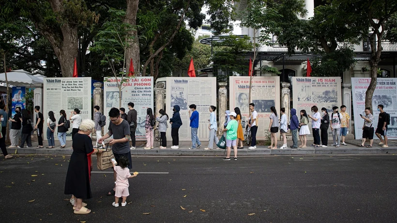 Une file de visiteurs faisant la queue pour découvrir l’exposition photographique « Éclat du nom de l’Oncle » et recevoir le supplément spécial du Journal Nhân Dân, à l’occasion du 135e anniversaire de la naissance du président Hô Chi Minh. Photo : NDEL