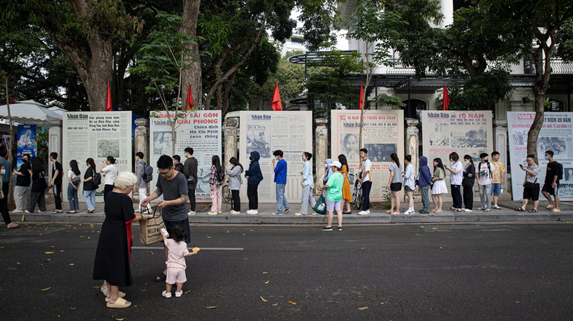 Une file de visiteurs faisant la queue pour découvrir l’exposition photographique « Éclat du nom de l’Oncle » et recevoir le supplément spécial du Journal Nhân Dân, à l’occasion du 135e anniversaire de la naissance du président Hô Chi Minh. Photo : NDEL