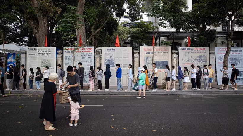 Une file de visiteurs faisant la queue pour découvrir l’exposition photographique « Éclat du nom de l’Oncle » et recevoir le supplément spécial du Journal Nhân Dân, à l’occasion du 135e anniversaire de la naissance du président Hô Chi Minh. Photo : NDEL