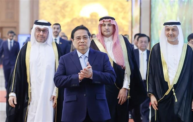 Le Premier ministre Pham Minh Chinh avec les ambassadeurs et le personnel des ambassades d’Arabie saoudite, des Émirats arabes unis et du Qatar à Hanoi, le 24 décembre. Photo: VNA