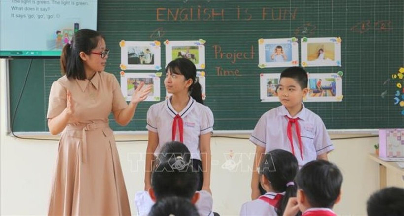 Un enseignant guide des élèves dans un jeu en anglais. Photo : VNA
