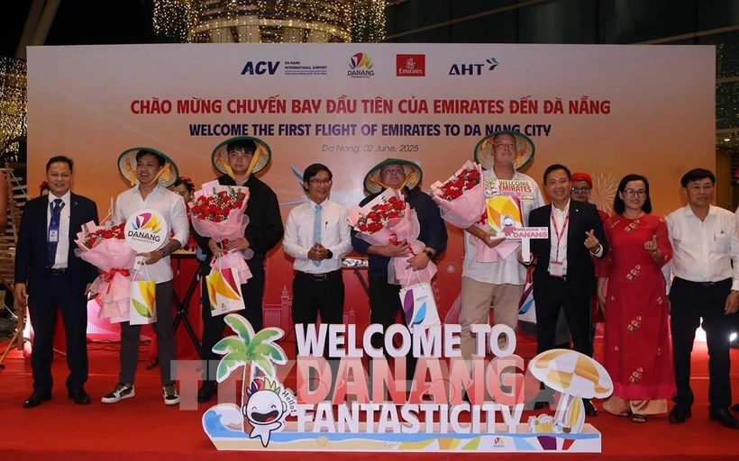 Le comité d'organisation a offert des fleurs pour féliciter les premiers passagers arrivés à Dà Nang par un vol d'Emirates. Photo : VNA