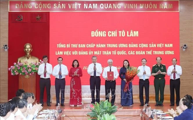 Le secrétaire général Tô Lâm remet au Comité du Parti du FPV et aux organisations de masse centrales la décision n°304-QD/TW du Politburo, à Hanoi, le 23 juin. Photo : VNA