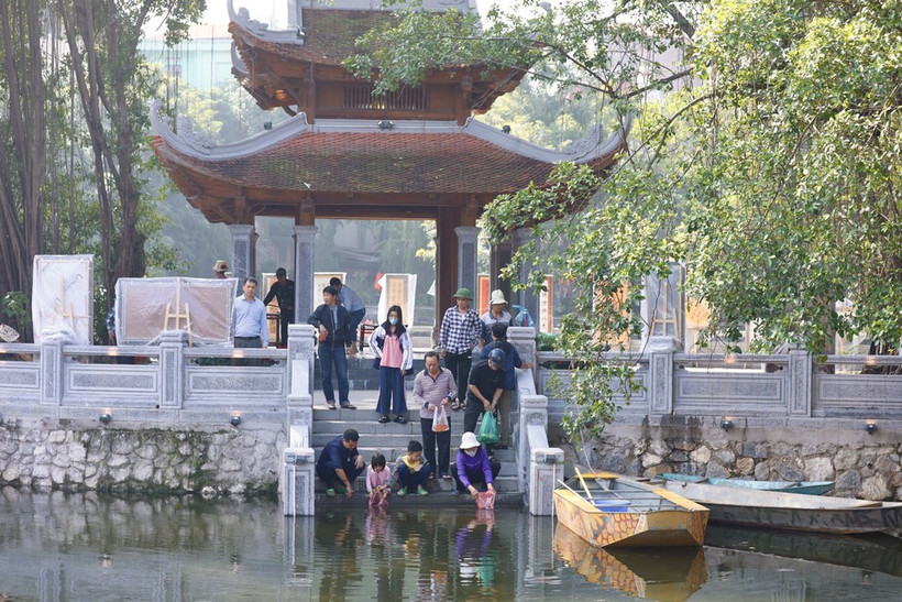 Des petites carpes rouges sont relâchés dans lac Van (Littérature), à Dông Da, Hanoi pour amener les Génies du Foyer au Ciel, selon la croyance. Photo : VNA