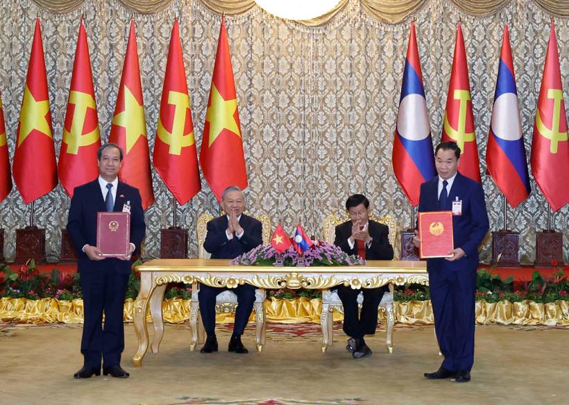 Le secrétaire général du Parti communiste du Vietnam, Tô Lâm, et le secrétaire général du Parti révolutionnaire populaire lao et président lao, Thongloun Sisoulith supervisent l’échange des accords de coopération entre les deux pays. Photo : VNA