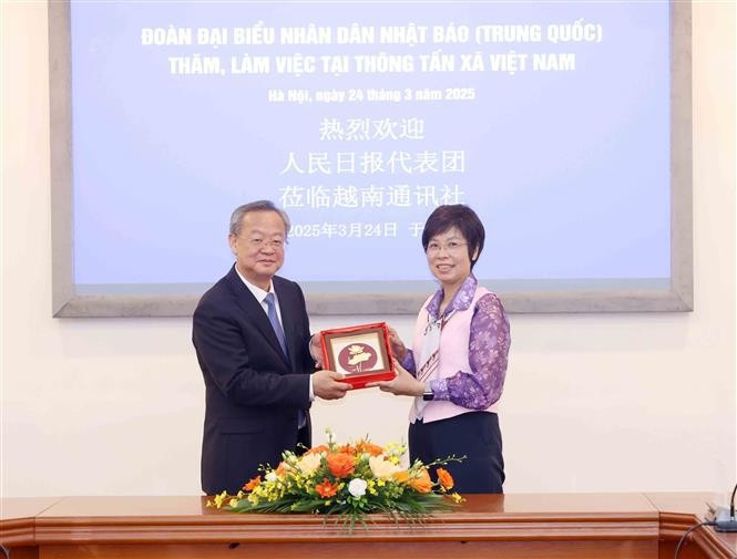 La directrice générale de l’Agence vietnamienne d’information (VNA), Vu Viêt Trang, offre un cadeau de souvenir au rédacteur en chef du Quotidien du Peuple de la Chine, Chen Jianwen. Photo: VNA