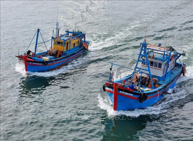 Deux bateaux de pêche partant au large. Photo : VNA