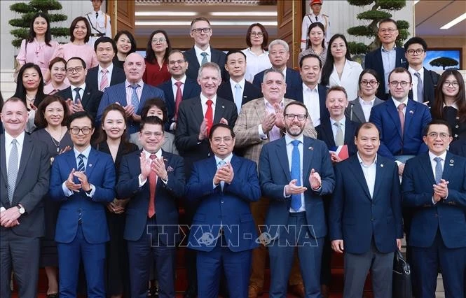 Le Premier ministre Pham Minh Chinh pose pour une photo souvenir avec les délégués lors de l'événement, à Hanoi, le 28 juin. Photo: VNA