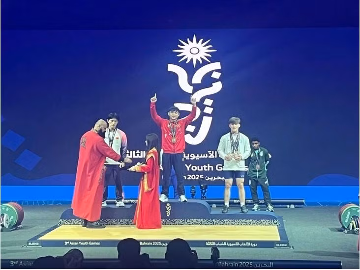 L’haltérophile Nguyên Thành Duy (au centre) sur la plus haute marche du podium, aux Jeux asiatiques de la jeunesse 2025, à Bahreïn, le 27 octobre. Photo : D.Q