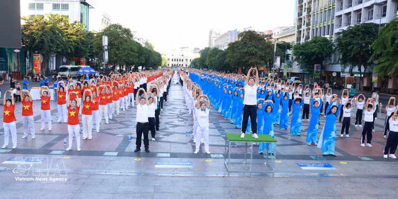 Professionnels de la santé et résidents de Hô Chi Minh-Ville pratiquent ensemble des exercices de promotion de la santé. Photo: VNA