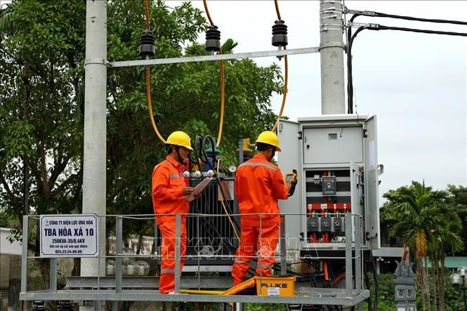 Des employés de la compagnie d’électricité de Hanoi (EVNHANOI) inspectent des équipements électriques. Photo : VNA