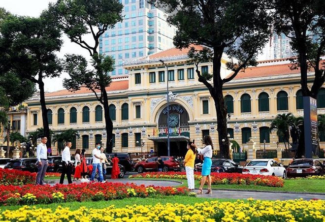 Des touristes devant la Poste centrale de Hô Chi Minh-Ville. Photo: VNA