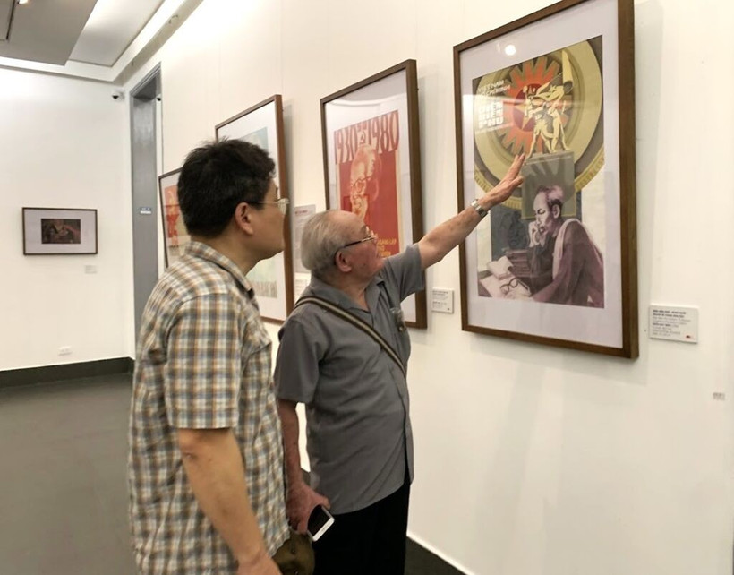 Le peintre Trân Duy Truc (droite) présente son œuvre à l’exposition.