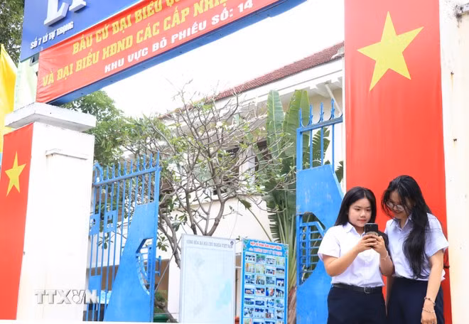 Des électrices âgées de 18 ans du lycée Ly Tu Trong s'informent sur les élections. Photo: VNA