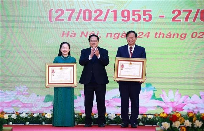 Le Premier ministre Pham Minh Chinh (centre) remet l’Ordre du travail de troisième classe au professeur associé Dr Dào Xuân Co, directeur de l’Hôpital Bach Mai, et le titre de docteure émérite à Nguyên Thi Mai Ngoc, à l’Institut national de cardiologie du Vietnam relevant de l’Hôpital Bach Mai. (Photo : VNA)