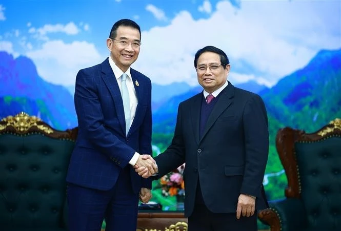 Le Premier ministre Pham Minh Chinh (à droite) serre la main du ministre thaïlandais des Affaires étrangères Maris Sangiampongsa, à Hanoi, le 24 février. Photo: VNA