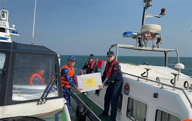 Les garde-côtes vietnamiens et chinois s'offrent les uns aux autres des cadeaux après la fin de leur patrouille conjointe. Photo: VNA