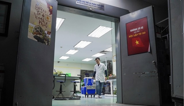 Tôt le matin, le pharmacien Nguyên Hoàng Minh prépare des conteneurs de sang et de produits sanguins au sein du service de stockage et de distribution du sang du Centre national de transfusion sanguine. Photo : dantri.com.vn